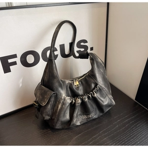 Detailed close-up of retro black pleated leather shoulder bag with embossed logo and side pocket