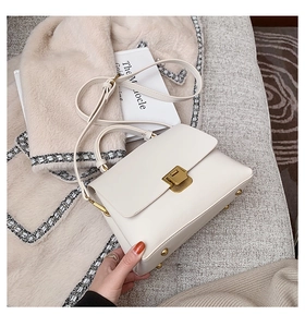 Détail du sac à main en cuir blanc crème avec fermoir doré et rivets de protection