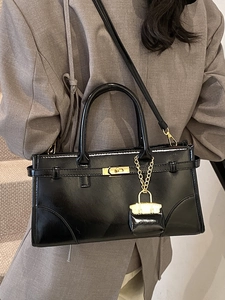 Classic black patent leather briefcase handbag with gold hardware and shoulder strap