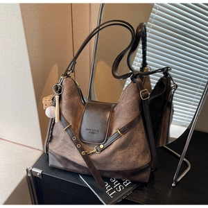 Close-up of vintage brown tote bag with brand embossing and sports-themed keychain