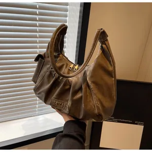 Detail showing the brown vintage pleated hobo bag with MKMT leather tag and handle