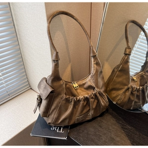 Detail view of a vintage dark brown wrinkled dumpling shoulder bag with pockets