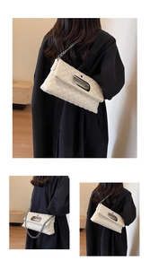 Detail einer weißen gesteppten Tote Bag mit silbernem Metallgriff und Kettenriemen