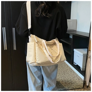 Detailed back view of a beige multi-pocket tote bag with straps worn by a model