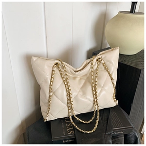 Detail view of cream quilted tote bag with gold chain strap and elegant faux leather texture