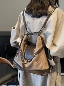 Vintage brown leather tote backpack with large capacity and baseball pendant charm