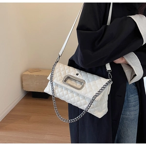 Detail der weißen gesteppten Handtasche mit ovalem Silbergriff und Metallkettendekor