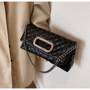 Detail der gesteppten Rautenmuster-Handtasche in Schwarz mit silbernem M-Logo und Kette