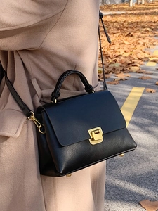 Sac à main classique en cuir noir avec fermoir doré dans un décor d'automne