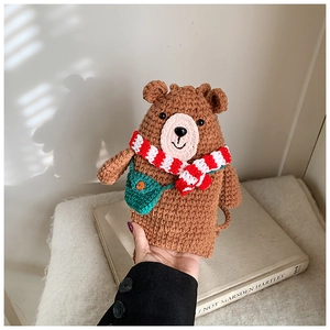 Detail of handmade crochet bear coin purse with striped scarf and cute green bag accessory