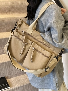 Minimalist beige oversized tote bag with functional pockets and woven rope zipper detail