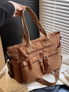 Brown nylon tote bag with multiple pockets and adjustable shoulder strap for casual use