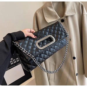 Detailansicht der schwarzen Stepptasche mit silbernem M-graviertem Metallgriff und Kette