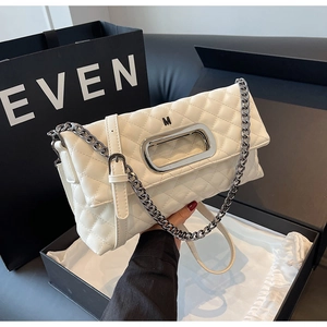 Detaillierte Nahaufnahme weiße Stepptasche mit M-Metalllogo und Luxus-Geschenkverpackung