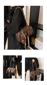 Detail der braunen Vintage-Schultertasche mit mehreren Taschen und süßem Bären-Anhänger