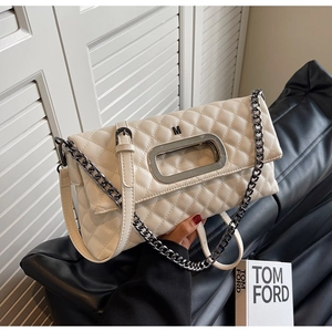 Detail der gesteppten beige Umhängetasche mit Metallgriff und Kettenriemen