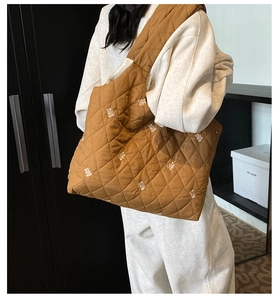 Detail of caramel quilted tote bag with white bear embroidery and spacious shoulder design