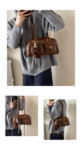 Detailansicht braune Retro-Ledertasche mit Schnallentaschen und Teddybär-Anhänger