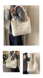 Detail of white quilted tote bag featuring brown bear embroidery and wide shoulder strap