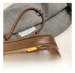 Detailaufnahme des glatten goldenen Metallreißverschlusses dieser braunen Leder-Umhängetasche