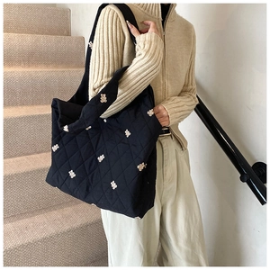 Detail of black quilted tote bag with bear embroidery on lightweight fabric material