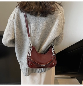 Détail du sac demi-lune bordeaux avec chaîne argentée et logo MZAGRAKE gravé