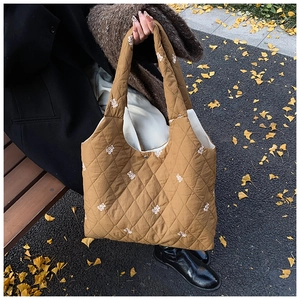 Caramel quilted tote bag featuring white bear embroidery and secure metal buckle closure