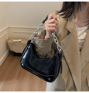 Vue détaillée du sac en cuir verni noir avec chaîne argentée et ornements de rivets