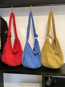 Three vibrant colorful wool tote bags in red, blue and yellow with knot strap detail