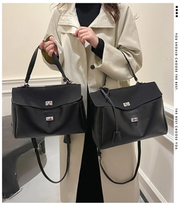 Detail view of two black leather handbags in medium and large sizes with silver hardware