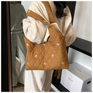 Detail of brown quilted tote bag with white bear embroidery and spacious soft interior