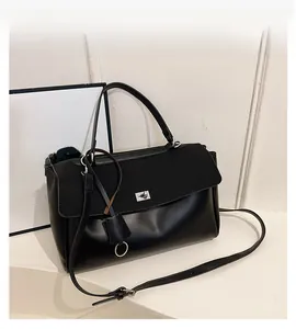 Close-up of elegant black leather handbag with metallic twist lock and soft glossy finish