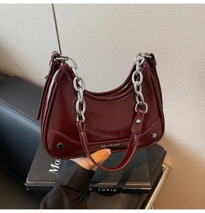 Détails du sac en cuir verni rouge foncé avec chaîne argentée et logo gravé