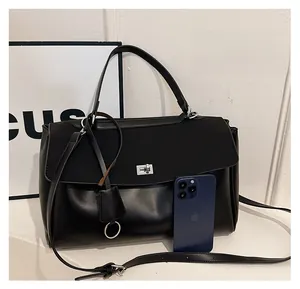 Size comparison of black matte leather tote bag with a mobile phone for scale