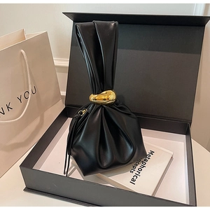 Détail du sac nuage en cuir plissé noir avec finitions dorées et emballage cadeau luxe
