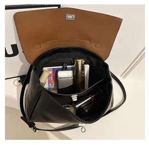 Detail view showing large interior capacity of the black leather bag with brown lining