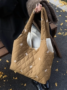 Brown quilted tote bag with white bear embroidery in an autumn outdoor park setting