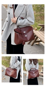 Close-up of a deep burgundy leather satchel with silver lock and adjustable strap