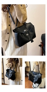 Detail of black leather handbag with silver buckle lock and detachable shoulder strap