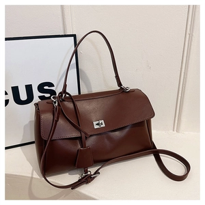 Detail of dark brown leather handbag with silver square twist lock and long shoulder strap