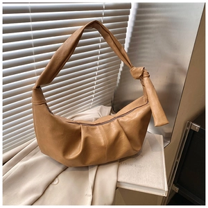 Detail of vintage caramel brown dumpling bag showing soft pleated leather and knot strap