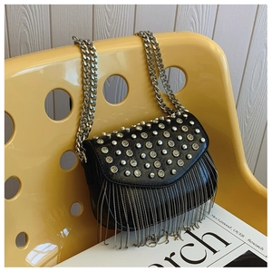 Detail of black square crossbody bag with silver studs and long metal chain fringe