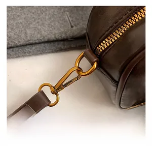 Detail view of premium bronze metal lobster clasp and lychee pattern leather shoulder strap