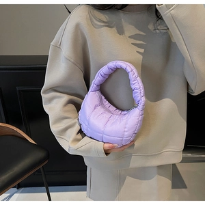 Detail of light purple quilted crescent handbag with shiny nylon finish and zipper closure