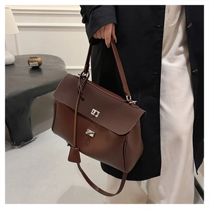 Close-up of a dark brown leather handbag featuring silver twist locks and a top handle