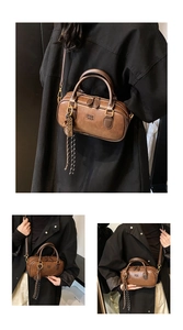 Detailed macro view of vintage brown Boston bag with embossed text and tassel charm