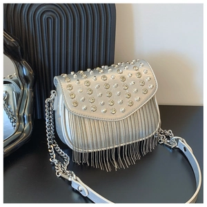Close-up of silver crossbody bag featuring sparkling rhinestone fringe and metal studs