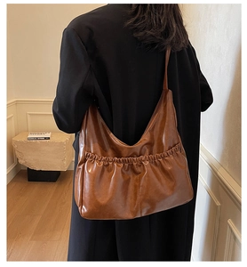 Detail der dunkelbraunen Falten-Hobo-Schultertasche mit weichem Glanzleder-Finish