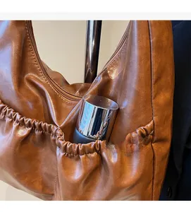 Detail der elastischen Seitentasche und Ledertextur der braunen Vintage Hobo Bag