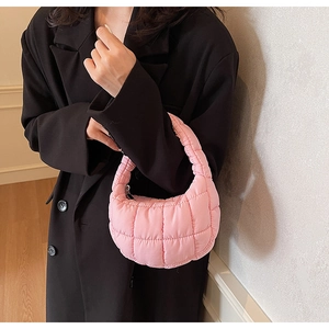 Detail of light pink quilted puffer hobo bag with a soft cloud-like texture and zip closure